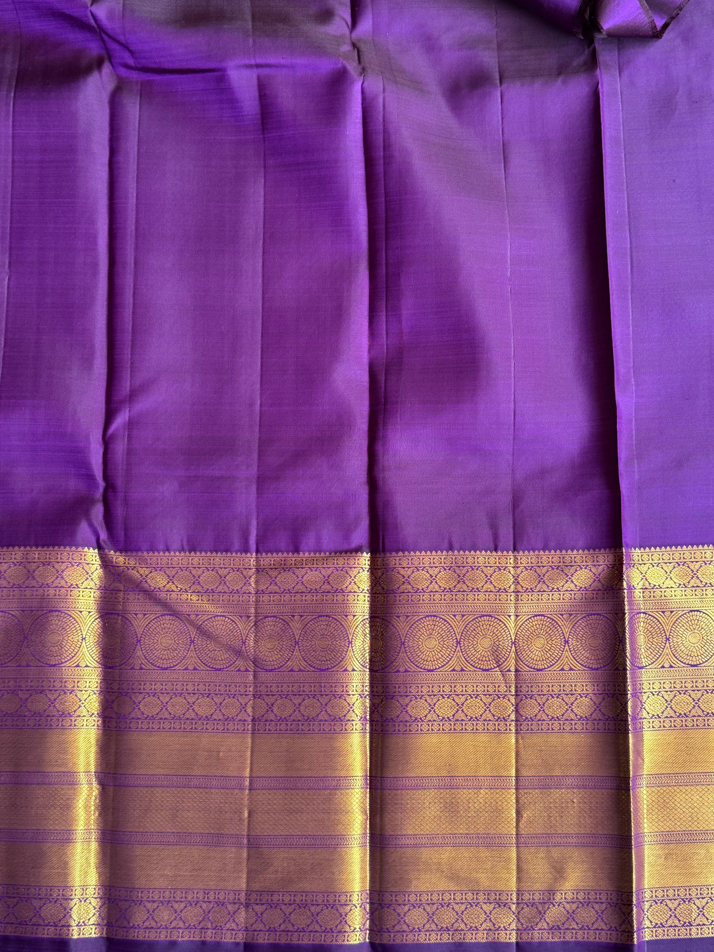 Pure Kanjivaram Silk Saree Grape Colored Elegantly Paid with a Gold Zari Border.