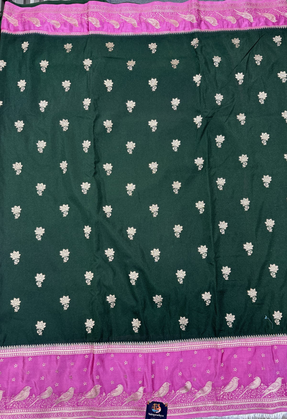 Banarasi Fancy Saree Bottle Green Colored Complemented with a Pink Zari Border.