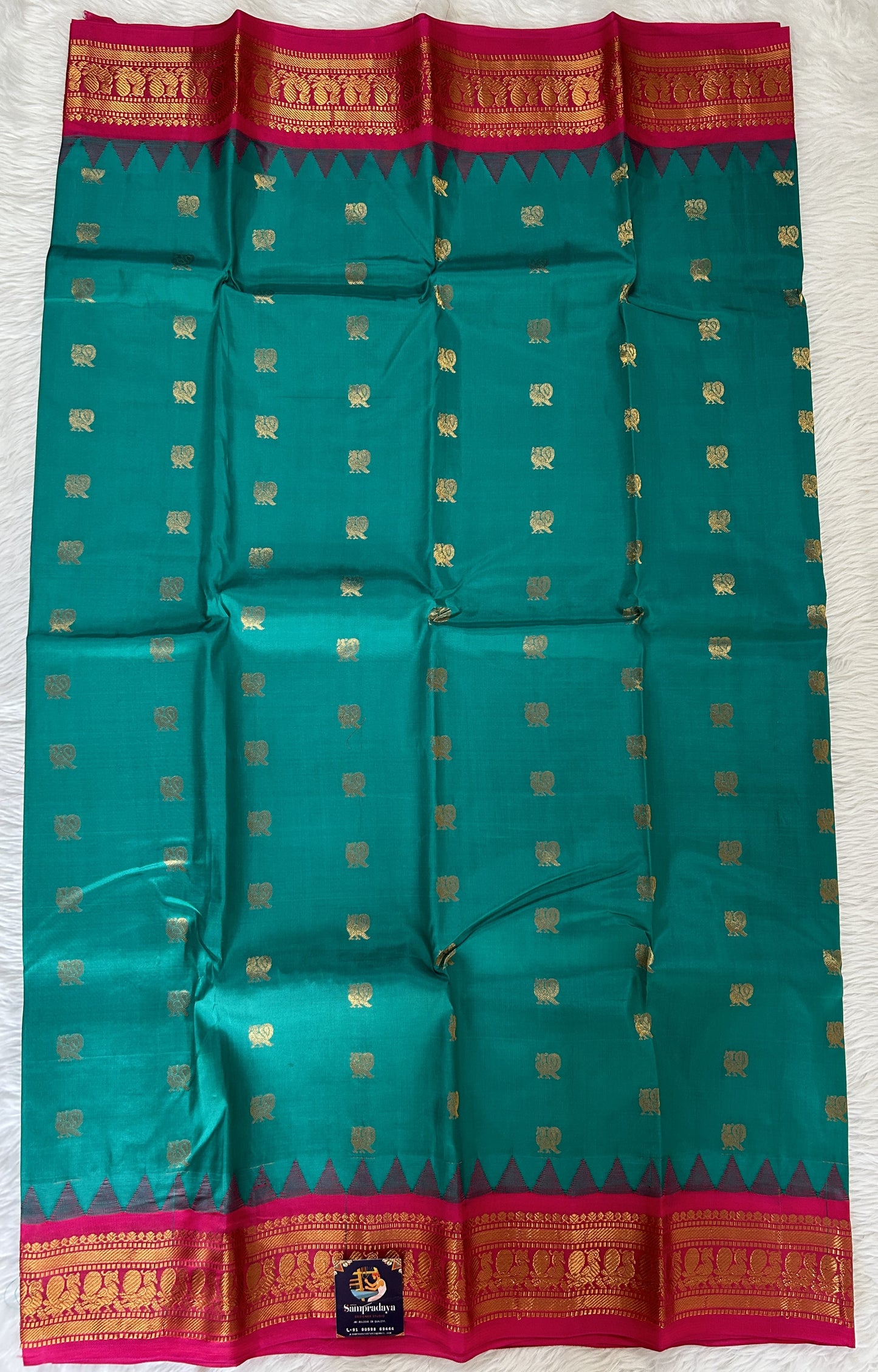Gadwal Pattu Saree Emerald Green colored saree complemented with a Pink Kanchi Border - Sampradaya Designer Studio