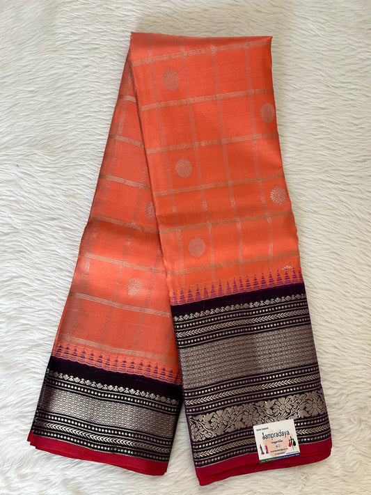 Gadwal Pattu Saree Orange colored saree complemented with a Dark Violet Kanchi Border - Sampradaya Designer Studio