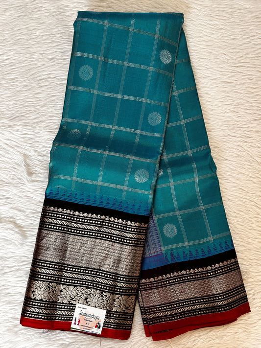 Gadwal Pattu Saree Aqua Blue colored saree complemented with a Dark Violet Kanchi Border - Sampradaya Designer Studio