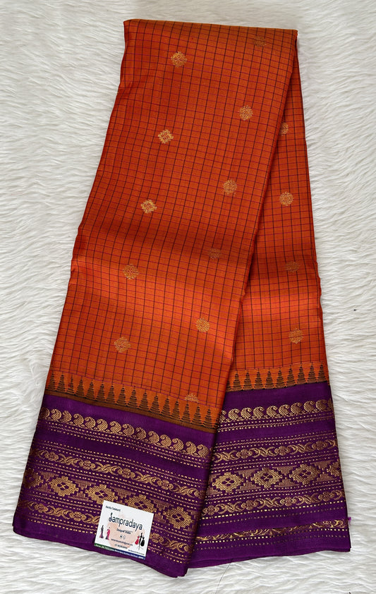 Gadwal Pattu Saree Orange colored saree complemented with a Dark Violet Kanchi Border - Sampradaya Designer Studio