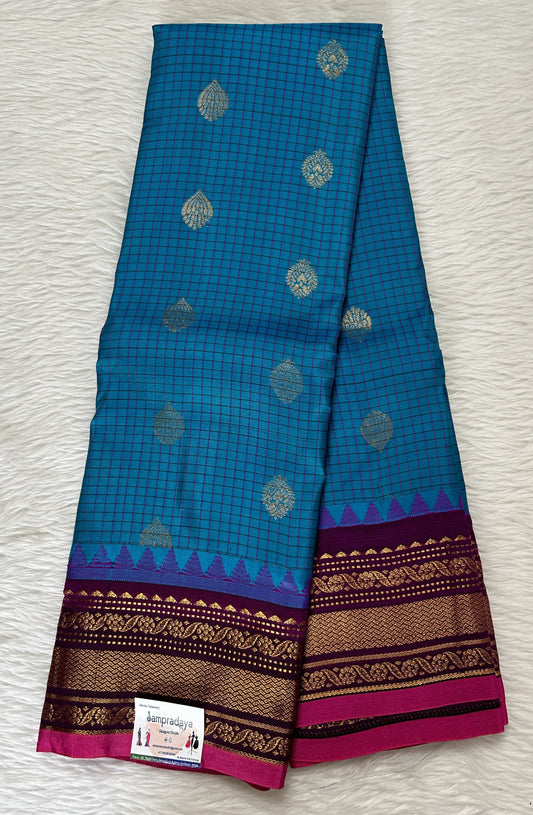 Gadwal Pattu Saree Turquoise Blue colored saree complemented with a Magenta Kanchi Border - Sampradaya Designer Studio