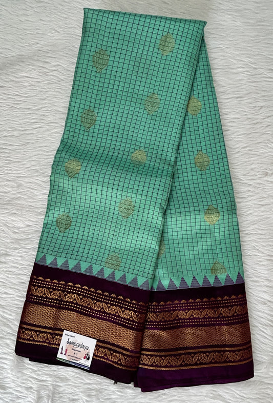 Gadwal Pattu Saree Emerald Green colored saree complemented with a Violet Color Kanchi Border - Sampradaya Designer Studio