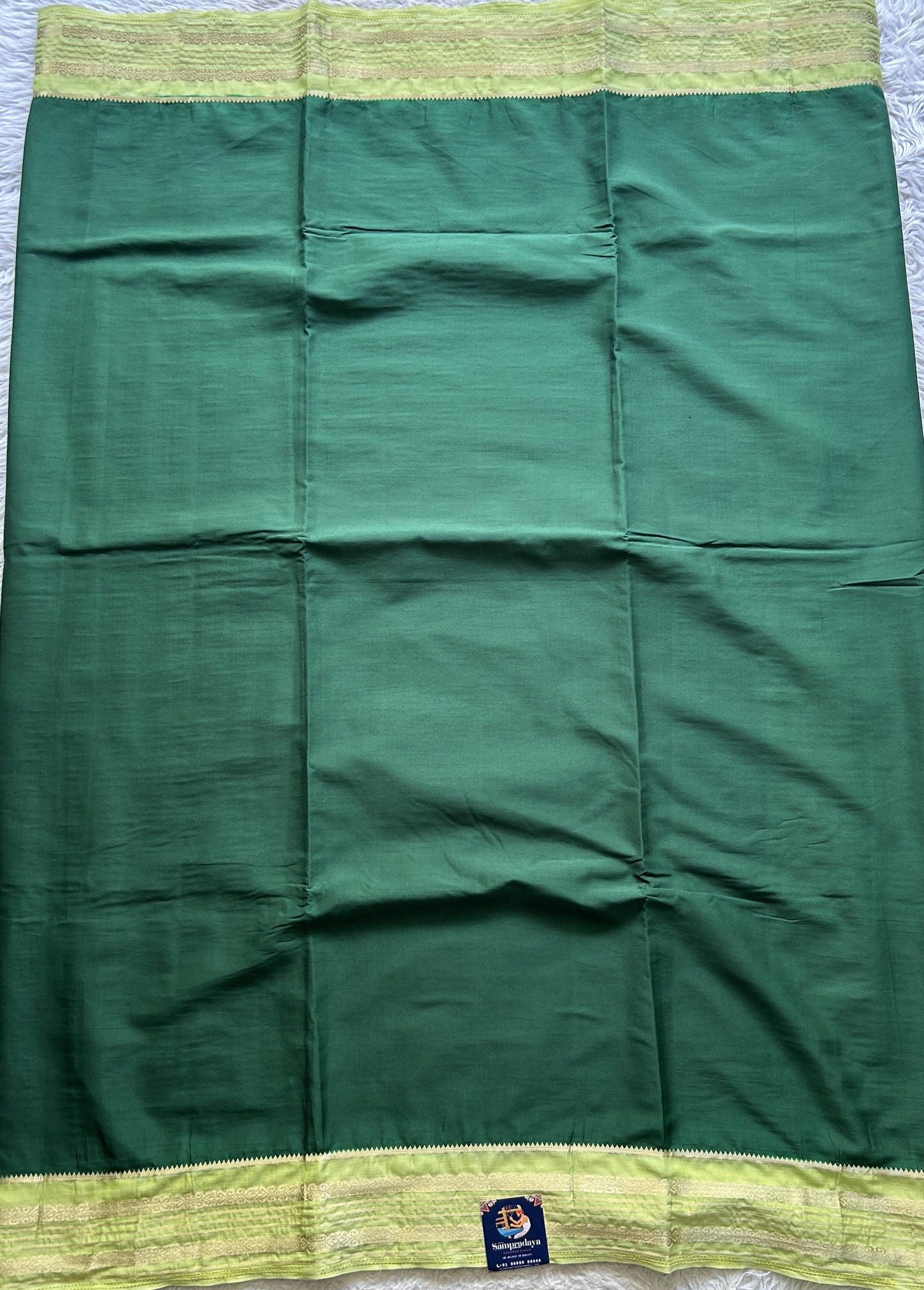 Semi Georgette Saree Dark Green Colored elegantly adorned with a Zari Border. - Sampradaya Designer Studio