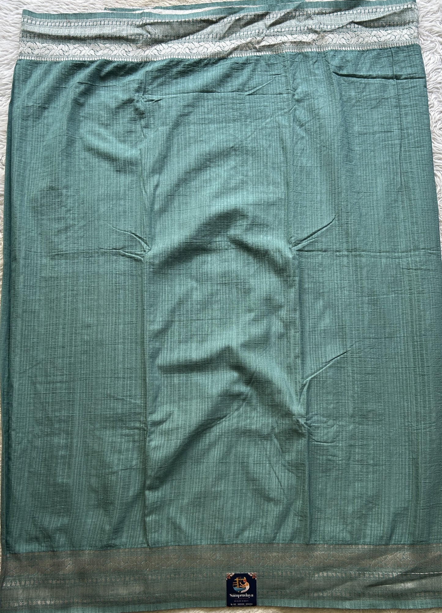 Semi Georgette Saree Sea Blue Colored elegantly adorned with a Zari Border. - Sampradaya Designer Studio