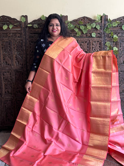 Pure Kanjivaram Silk Saree Peach Colored Elegantly Paid with a Gold Zari Border.