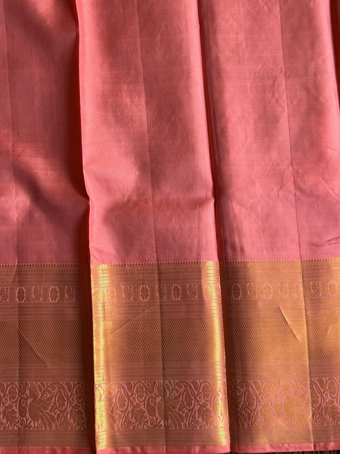 Pure Kanjivaram Silk Saree Peach Colored Elegantly Paid with a Gold Zari Border.