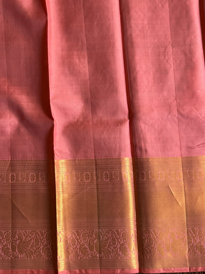 Pure Kanjivaram Silk Saree Peach Colored Elegantly Paid with a Gold Zari Border.