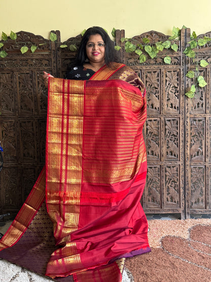 Pure Kanjivaram Silk Saree Burgundy Colored Complemented with a Gold Zari Border.