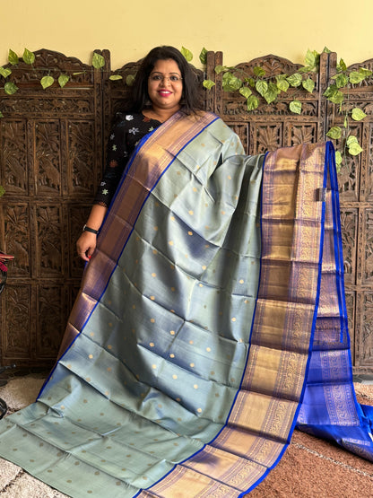 Pure Kanjivaram Silk Saree Grayish Blue Colored Elegantly Paid with a Gold Zari Border.