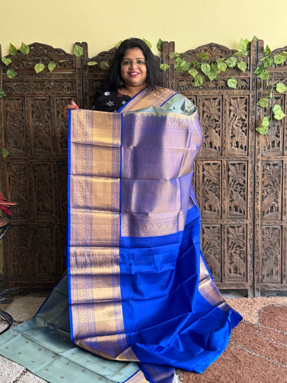 Pure Kanjivaram Silk Saree Grayish Blue Colored Elegantly Paid with a Gold Zari Border.