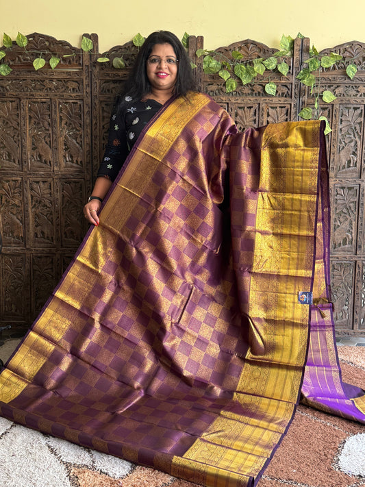Pure Kanjivaram Silk Saree Grape Colored Elegantly Paid with a Gold Zari Border.