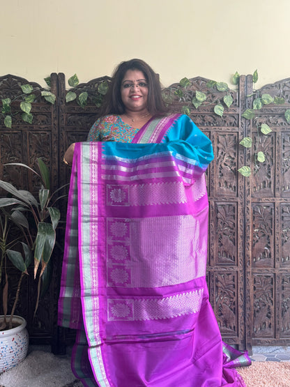 Gadwal Pattu Saree Peacock Blue colored saree complemented with a Purple Zari border - Sampradaya Designer Studio