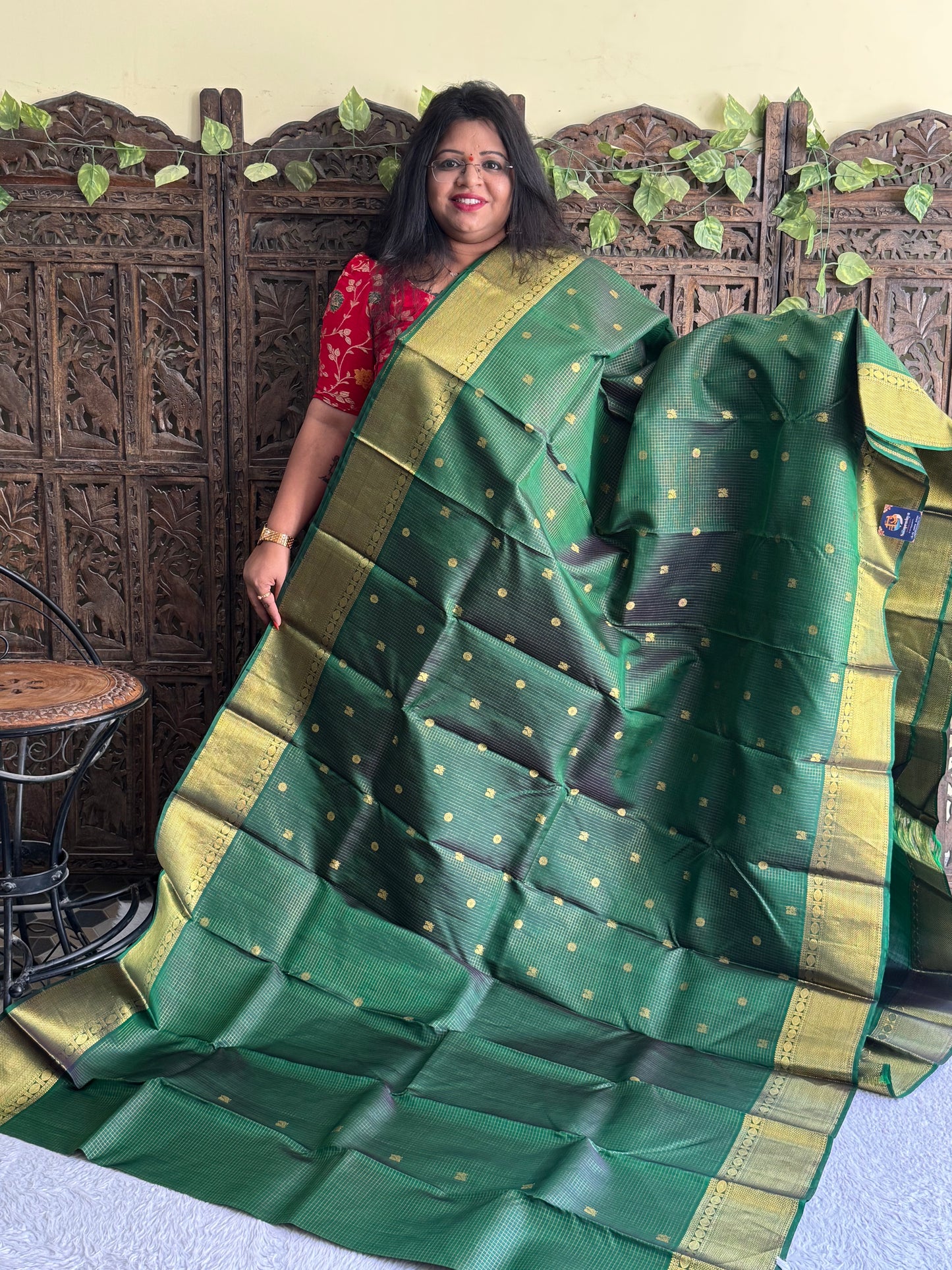 Pure Kanjivaram Silk Saree Bottle Green Colored Elegantly Paid with a Gold Zari Border.