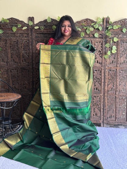 Pure Kanjivaram Silk Saree Bottle Green Colored Elegantly Paid with a Gold Zari Border.