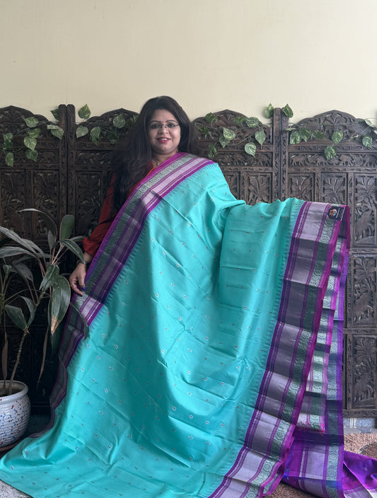 Gadwal Pattu Saree Cyan colored saree complemented with a Purple Zari border - Sampradaya Designer Studio