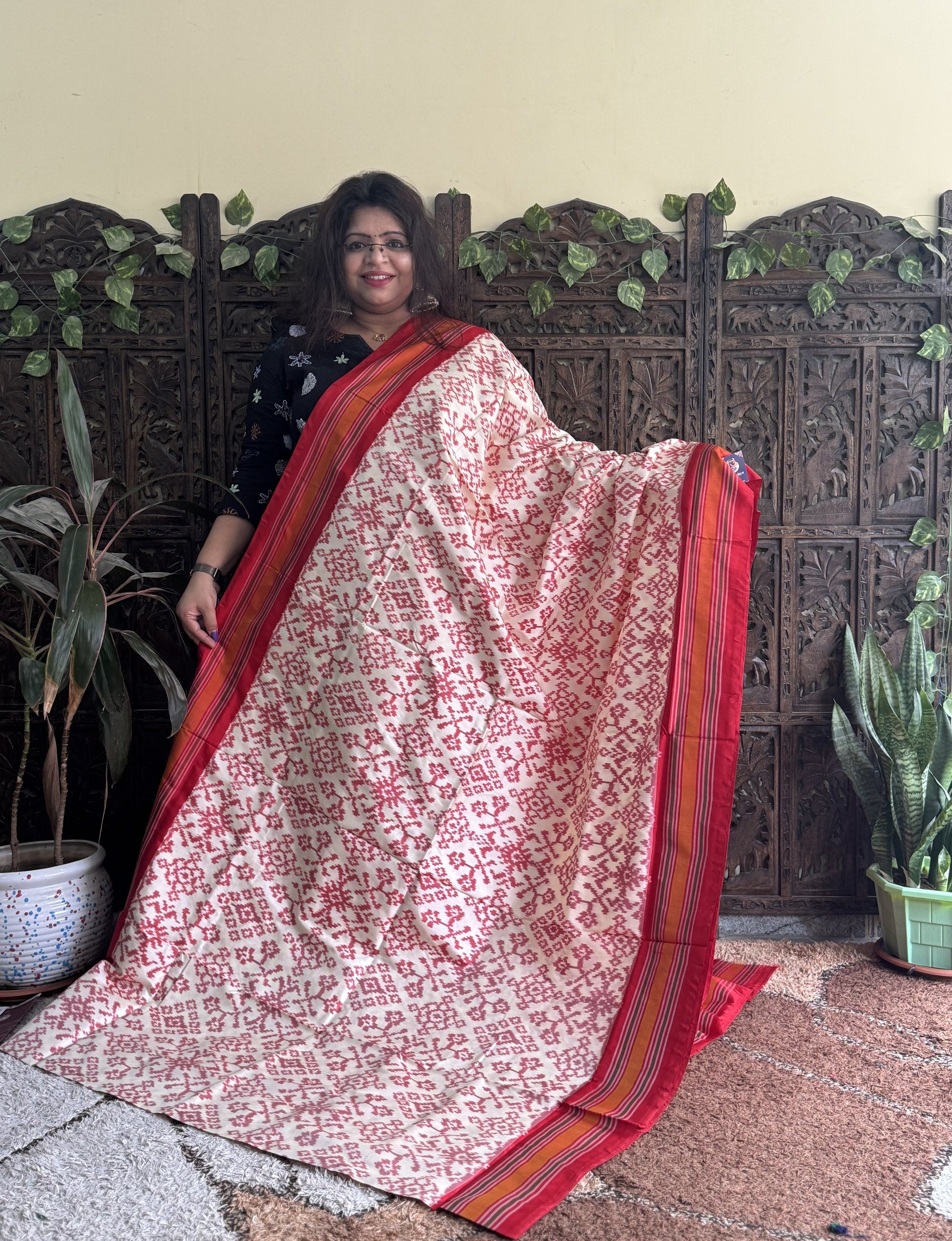 Ikkat Pattu Saree Cream colored complemented with a Red Patola border. - Sampradaya Designer Studio