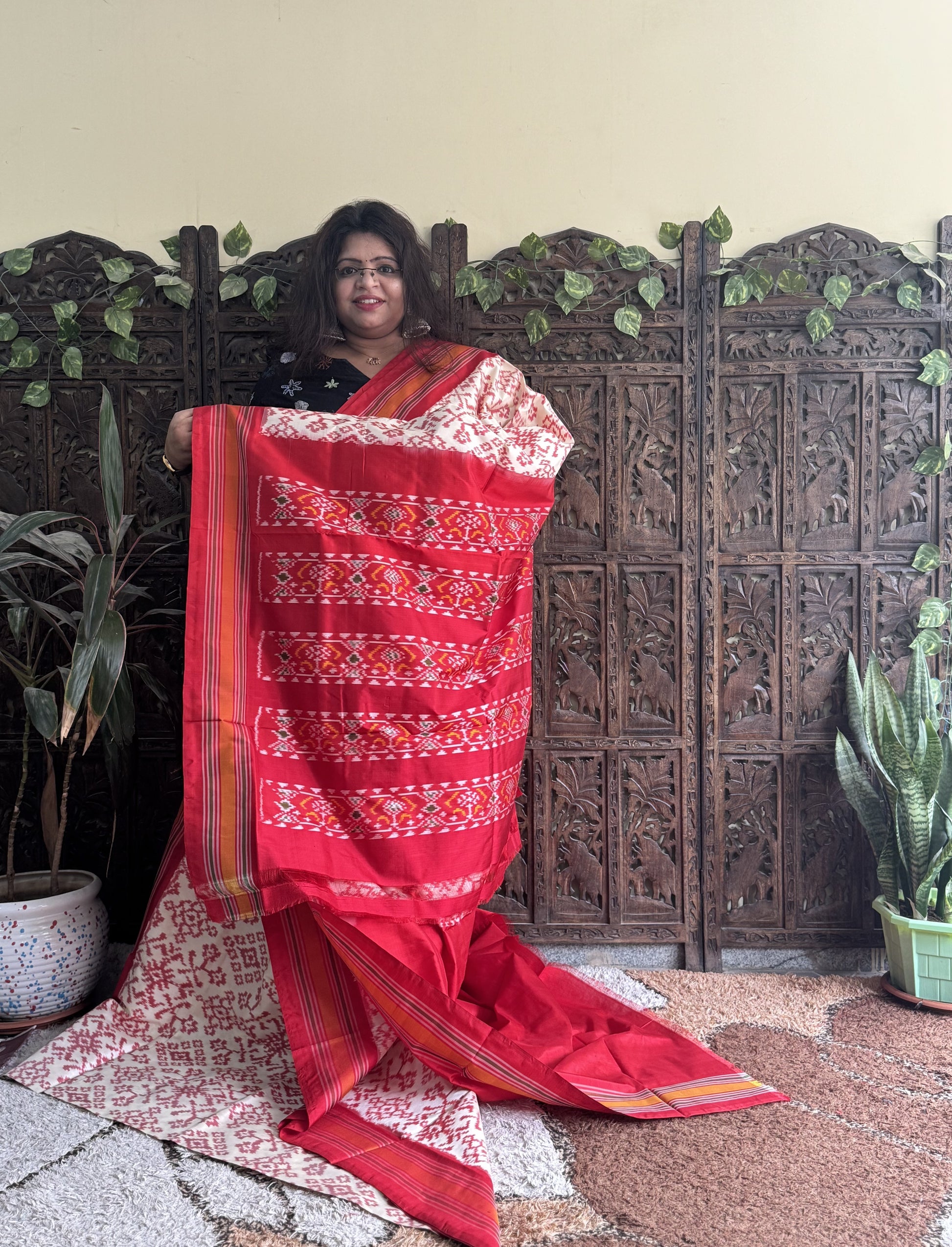 Ikkat Pattu Saree Cream colored complemented with a Red Patola border. - Sampradaya Designer Studio