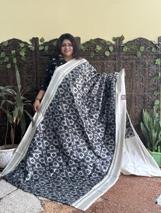 Ikkat Pattu Saree Gray colored complemented with a Patola border. - Sampradaya Designer Studio