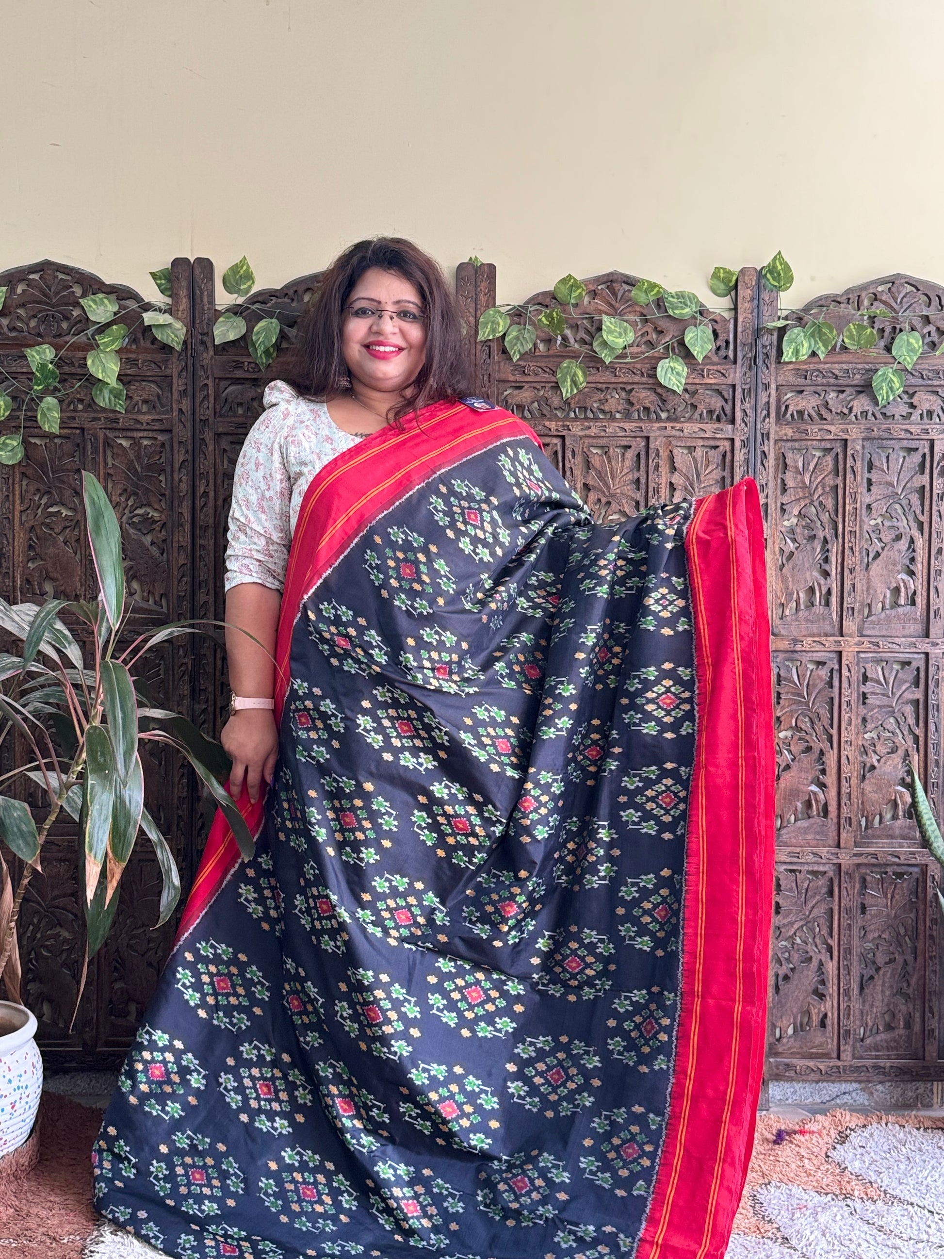 Ikkat Pattu Saree Black colored complemented with a Red Patola border. - Sampradaya Designer Studio