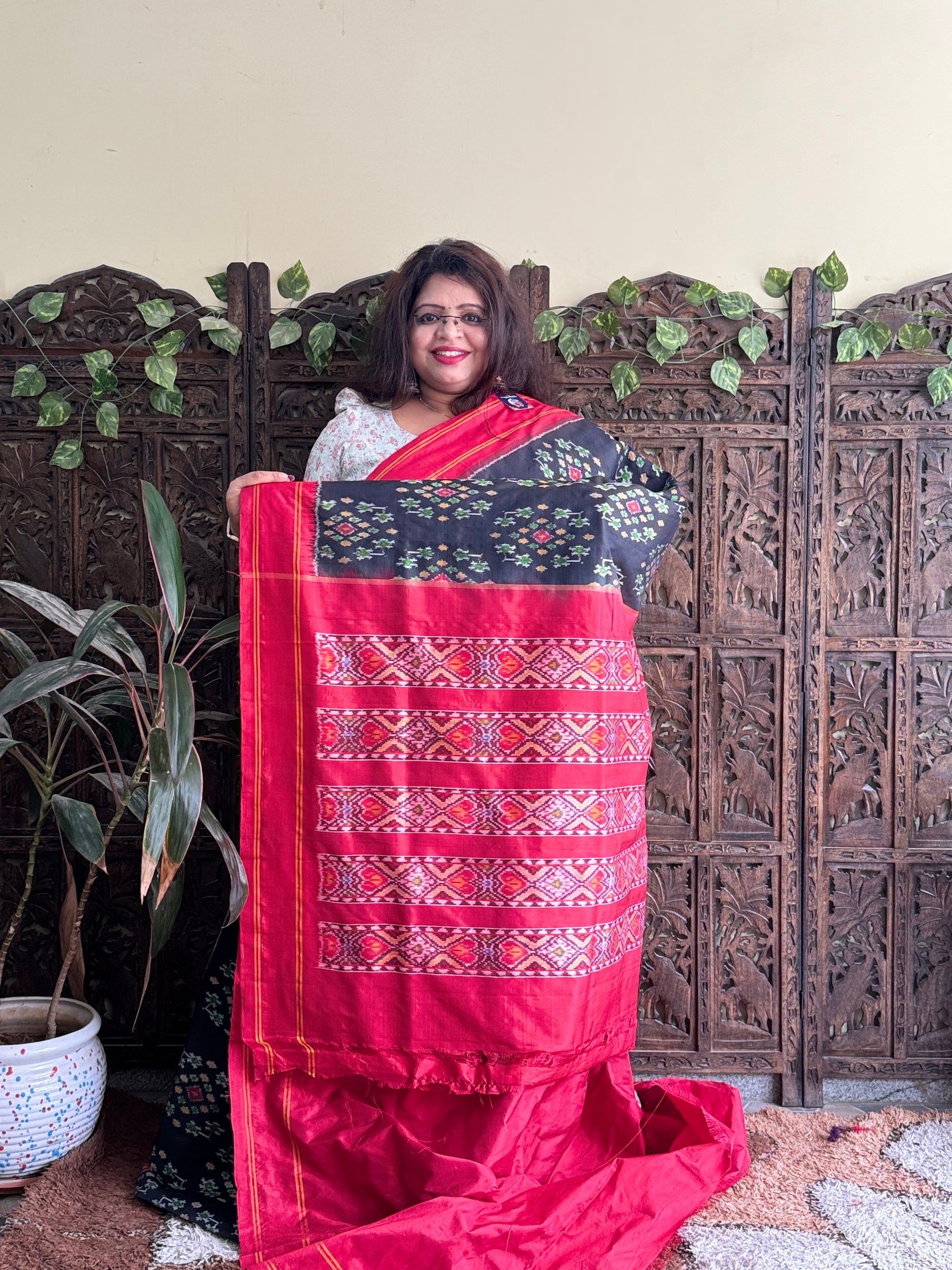 Ikkat Pattu Saree Black colored complemented with a Red Patola border. - Sampradaya Designer Studio