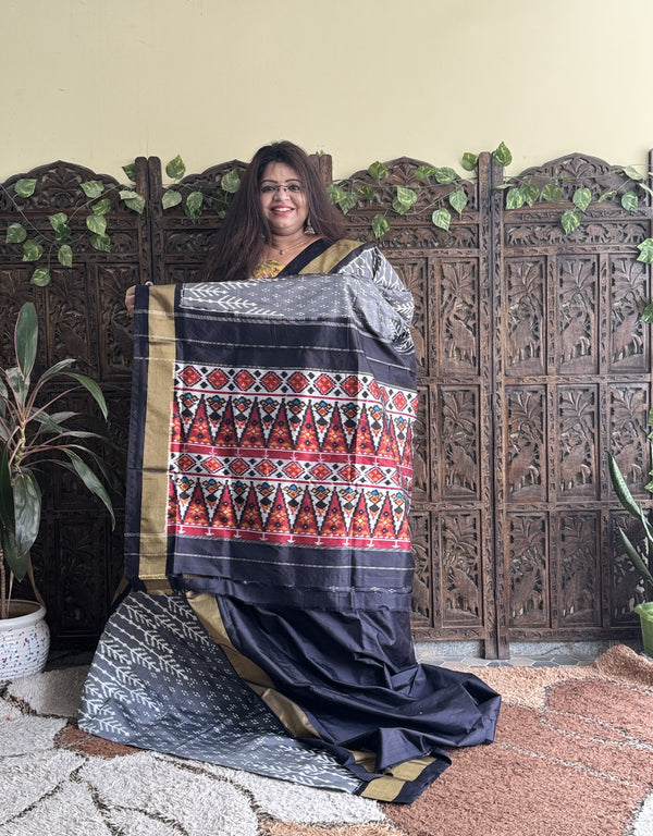 Ikkat Pattu Saree Gray colored complemented with a Black Zari border. - Sampradaya Designer Studio