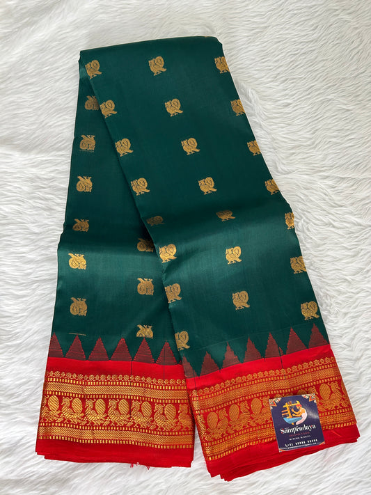 Gadwal Pattu Saree Bottle Green-colored saree complemented with a Red border - Sampradaya Designer Studio