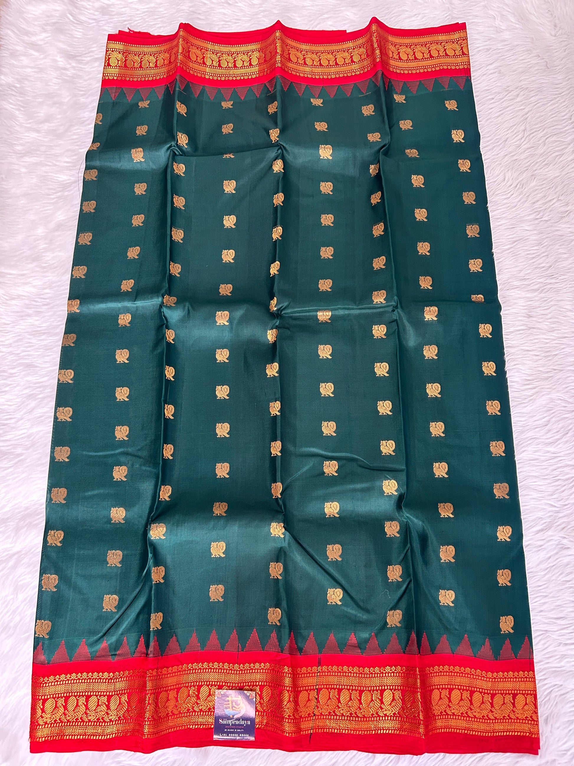 Gadwal Pattu Saree Bottle Green-colored saree complemented with a Red border - Sampradaya Designer Studio