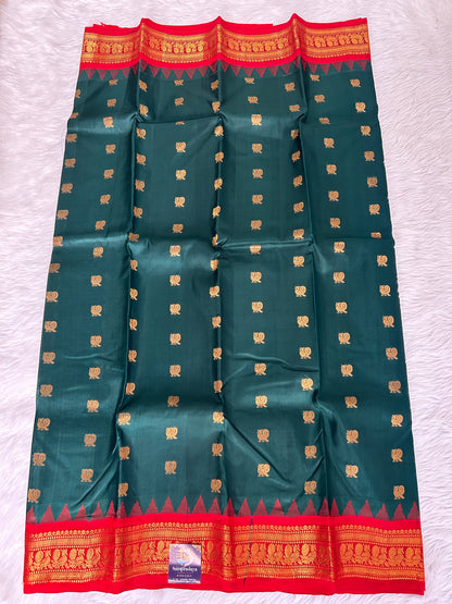 Gadwal Pattu Saree Bottle Green-colored saree complemented with a Red border - Sampradaya Designer Studio