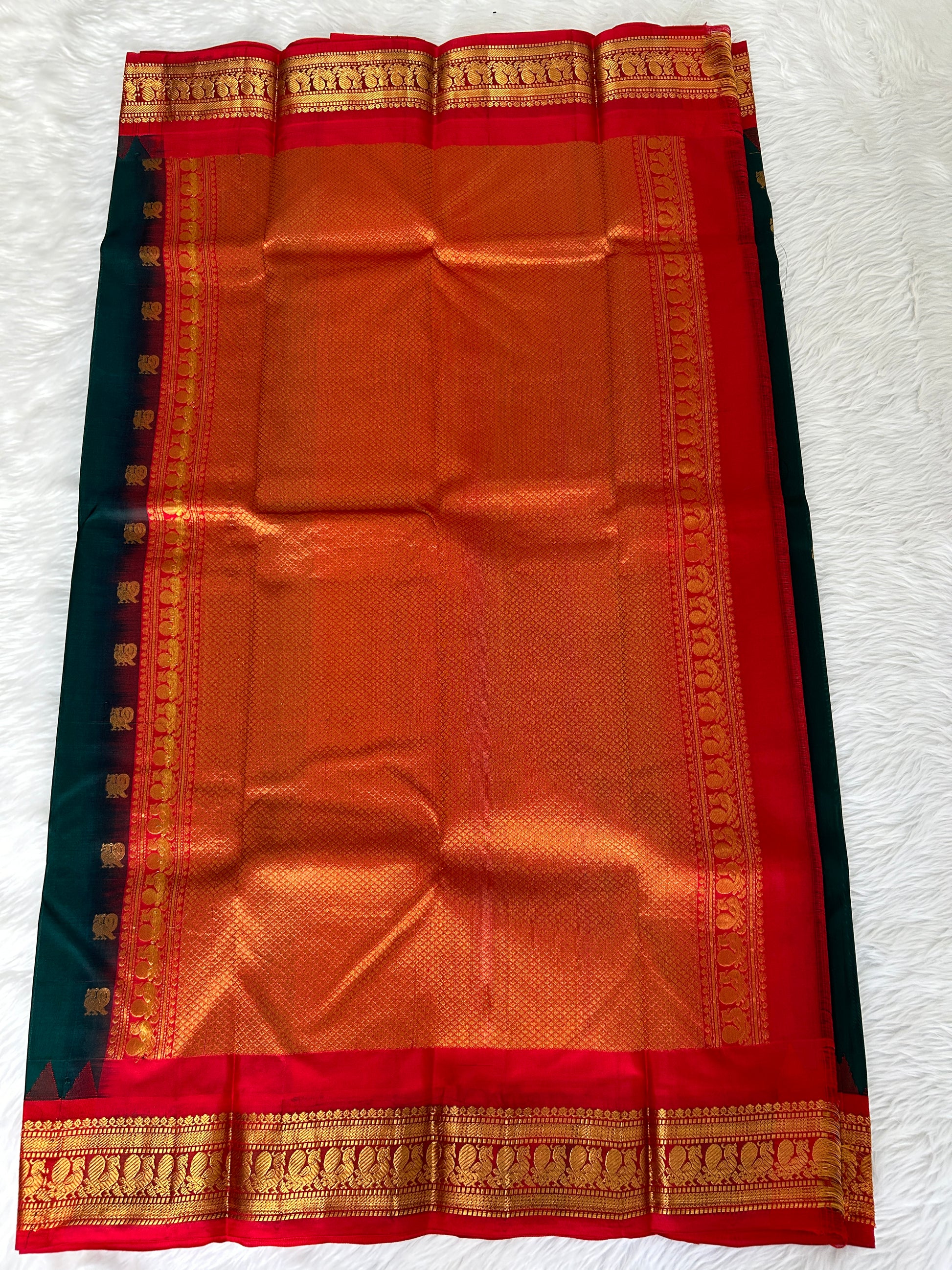 Gadwal Pattu Saree Bottle Green-colored saree complemented with a Red border - Sampradaya Designer Studio