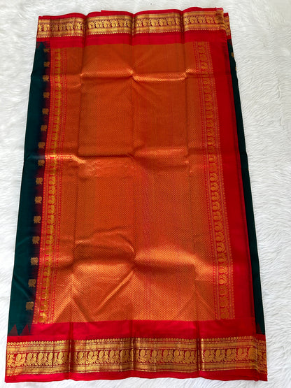 Gadwal Pattu Saree Bottle Green-colored saree complemented with a Red border - Sampradaya Designer Studio