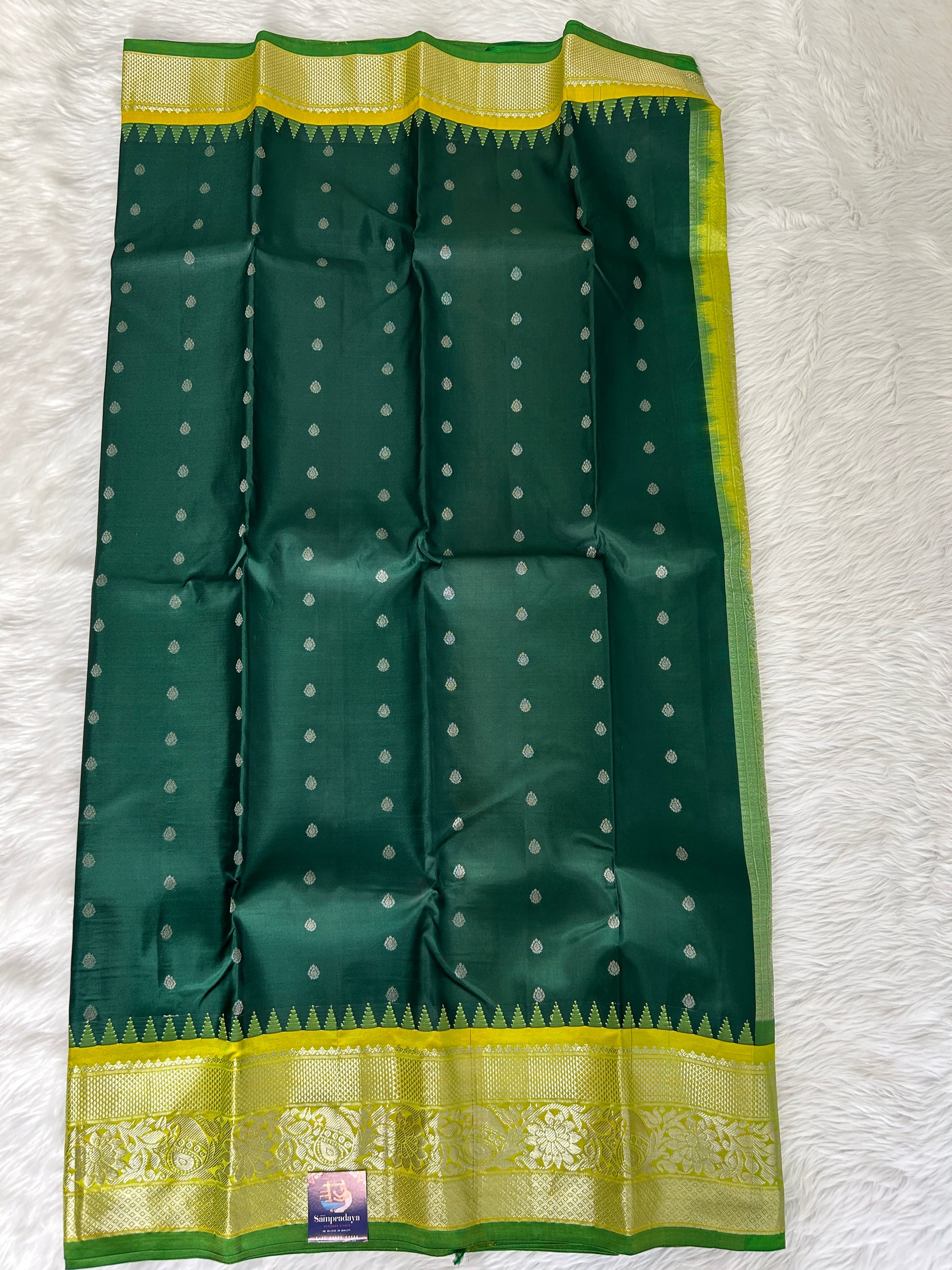 Gadwal Pattu Saree Bottle Green-colored saree complemented with a Lemon Yellow border - Sampradaya Designer Studio