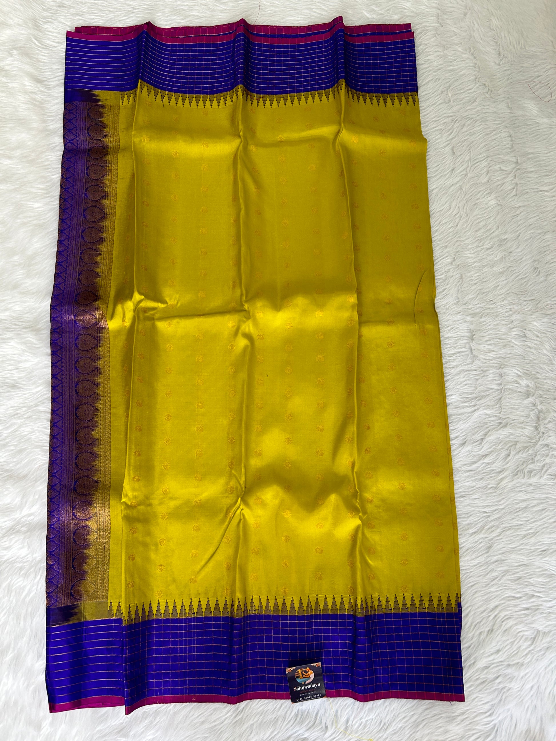Gadwal Pattu Saree Lemon Yellow colored saree complemented with a Royal Blue border - Sampradaya Designer Studio