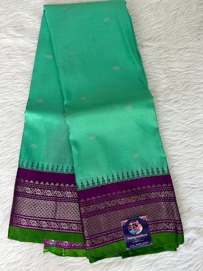 Gadwal Pattu Saree Greenish Cyan colored saree complemented with a Purple Kanchi border - Sampradaya Designer Studio