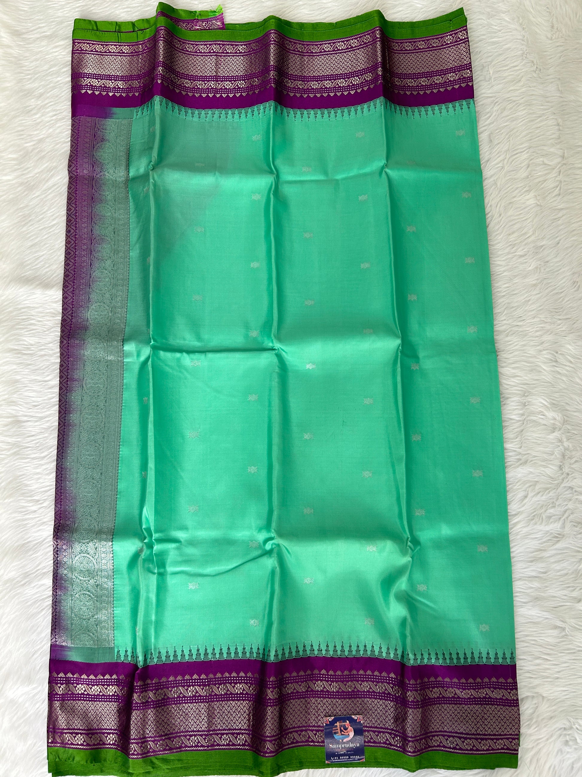 Gadwal Pattu Saree Greenish Cyan colored saree complemented with a Purple Kanchi border - Sampradaya Designer Studio