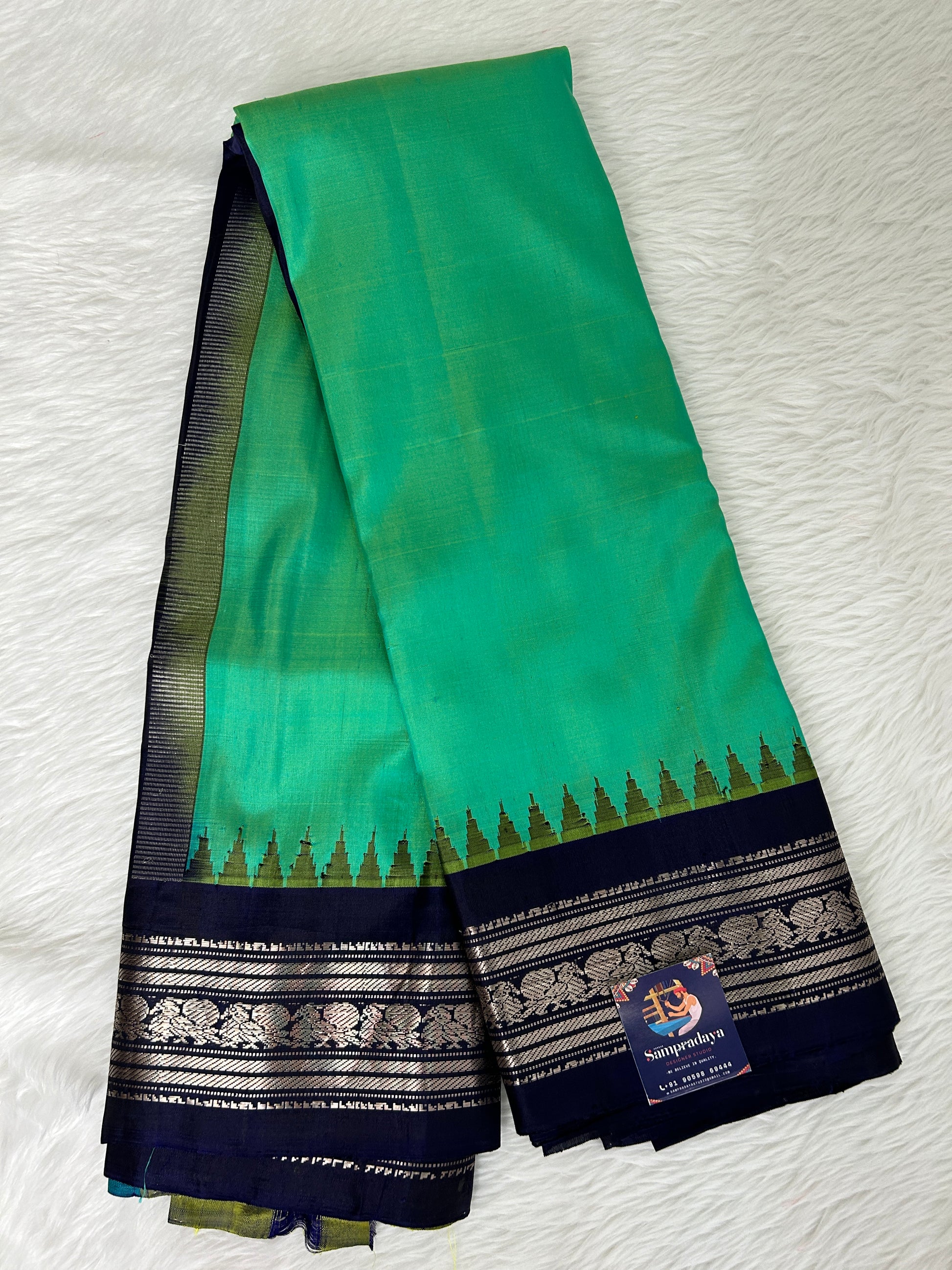 Gadwal Pattu Saree Green Colored Complemented With a Navy Blue Gap Border - Sampradaya Designer Studio