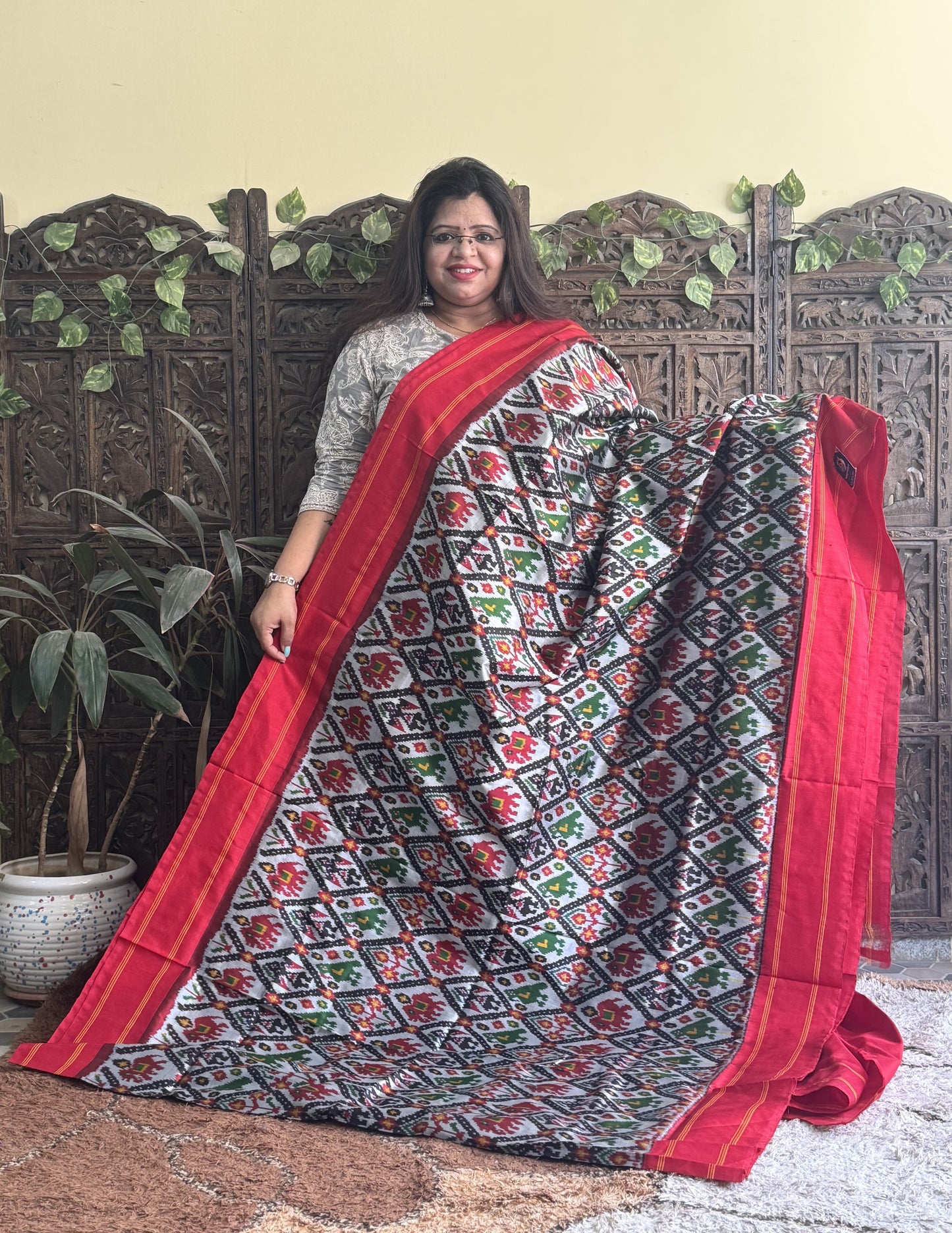 Ikkat Pattu Saree Gray colored complemented with a Red Patola border. - Sampradaya Designer Studio