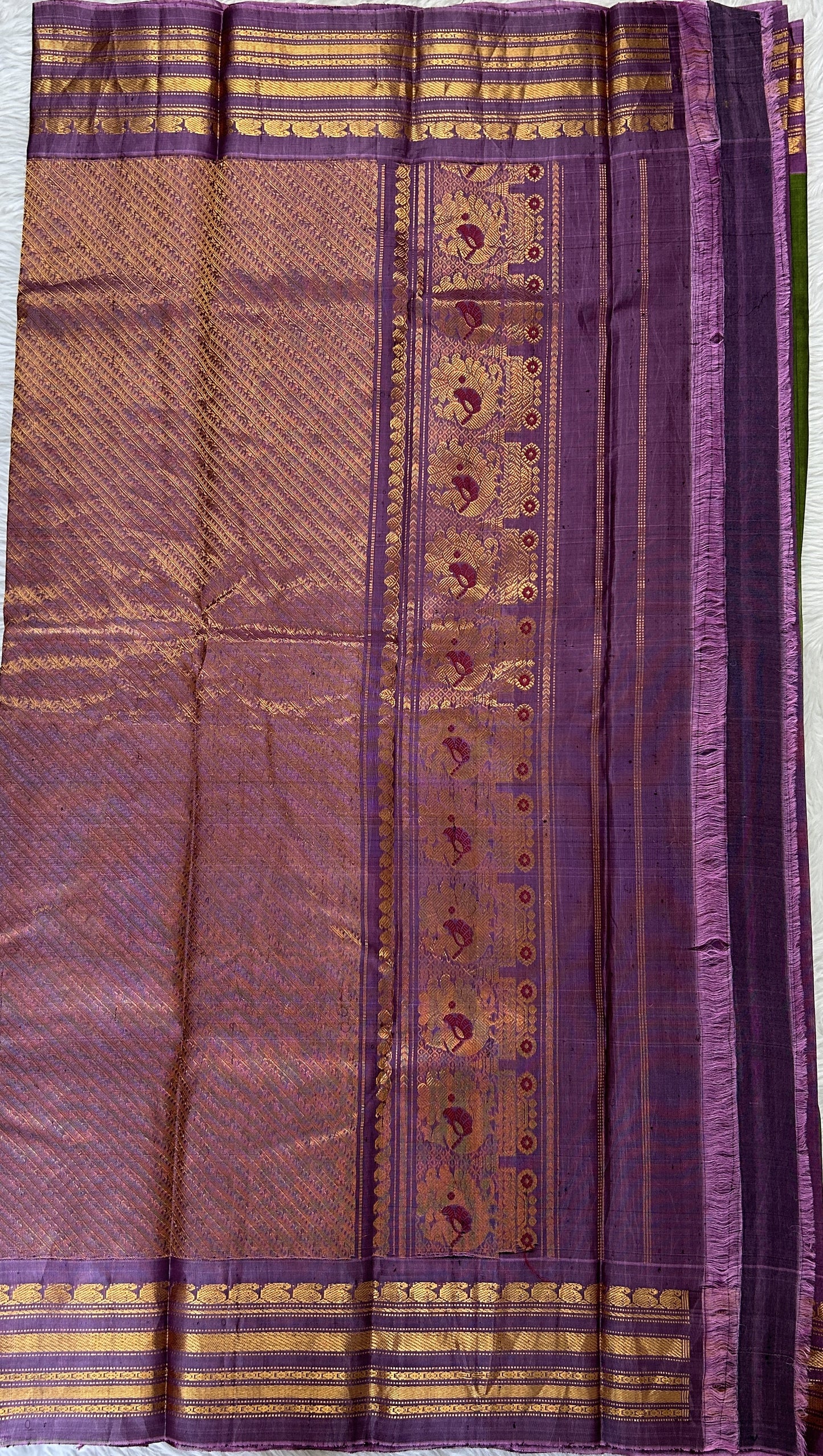 Gadwal Sico Saree Green colored complemented with a Lavender Kanchi Border. - Sampradaya Designer Studio