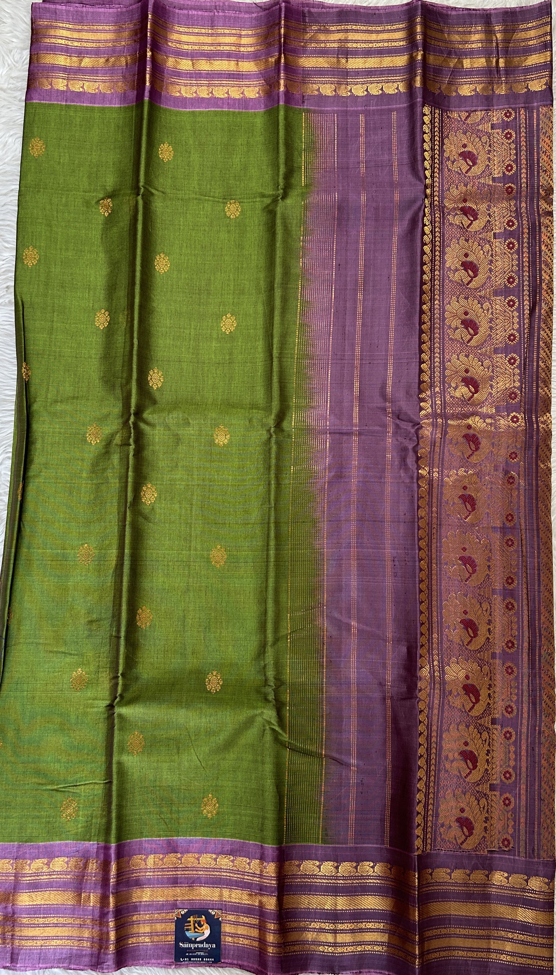 Gadwal Sico Saree Green colored complemented with a Lavender Kanchi Border. - Sampradaya Designer Studio