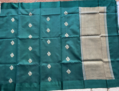 Pure Chiniya Silk Saree Bottle Green Colored Elegantly Paired with a Gold Zari Border.