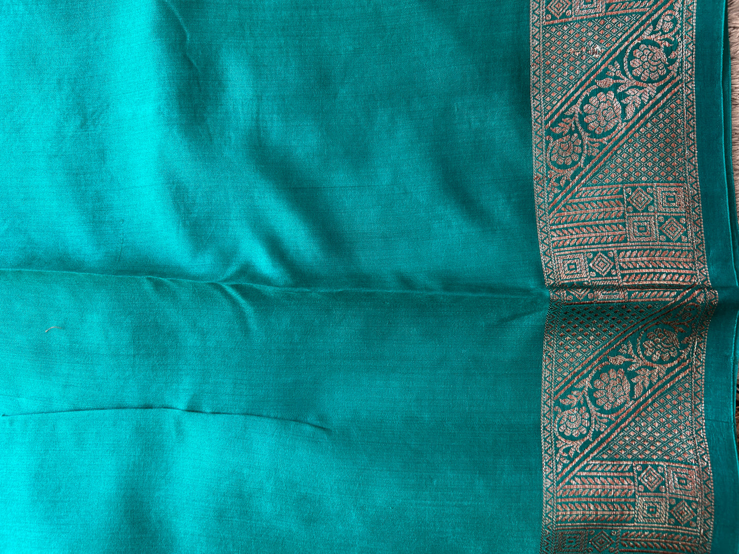 Pure Chiniya Silk Saree Rama Green Colored Elegantly Paired with a Gold Zari Border.