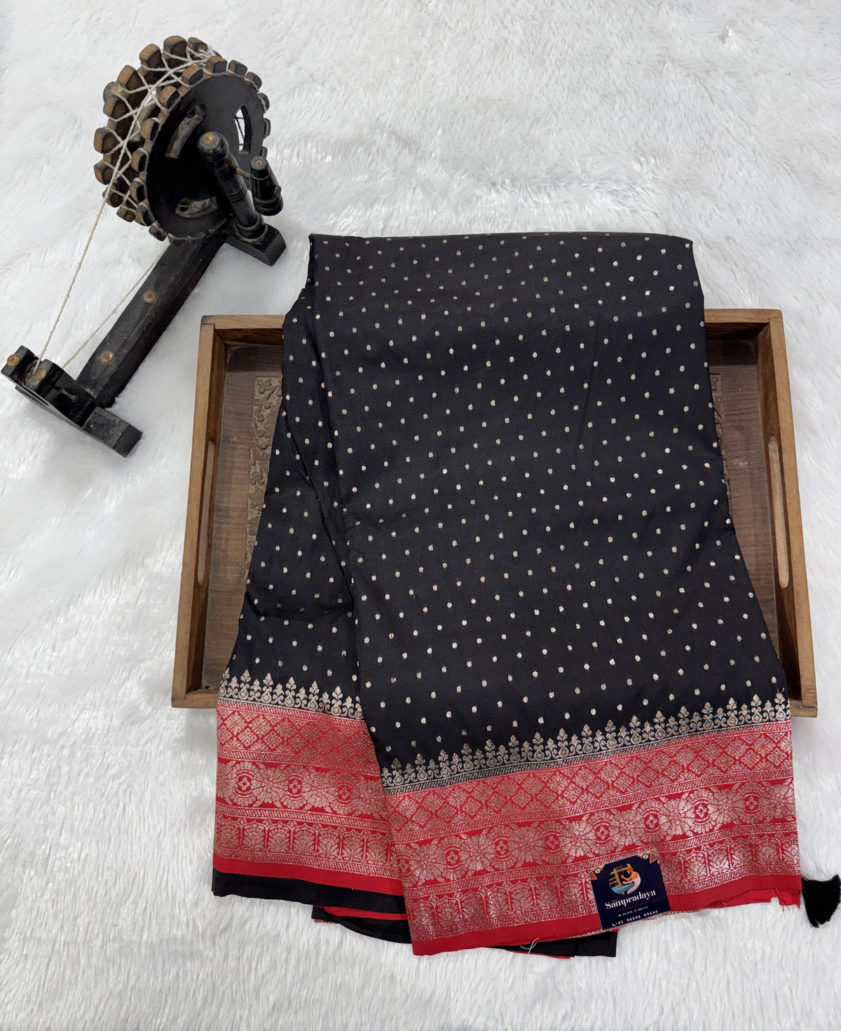 Banarasi Fancy Saree Black Colored Complemented with a Red Zari Border.