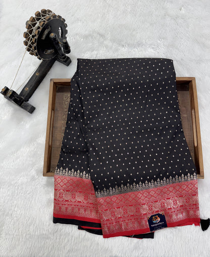 Banarasi Fancy Saree Black Colored Complemented with a Red Zari Border.