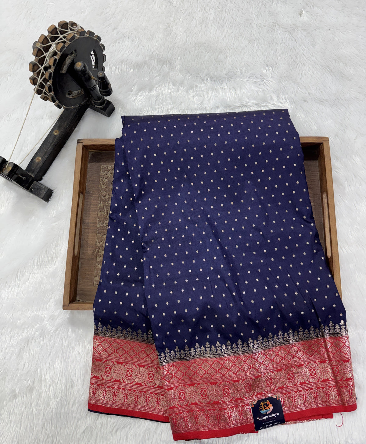 Banarasi Fancy Saree Navy Blue Colored Complemented with a Red Zari Border.