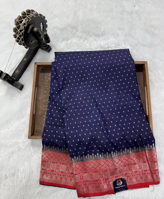 Banarasi Fancy Saree Navy Blue Colored Complemented with a Red Zari Border.