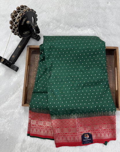 Banarasi Fancy Saree Bottle Green Colored Complemented with a Red Zari Border.