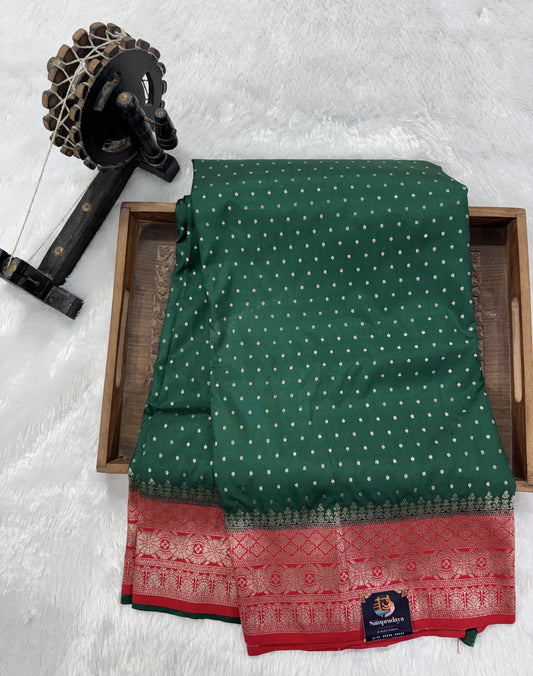 Banarasi Fancy Saree Bottle Green Colored Complemented with a Red Zari Border.
