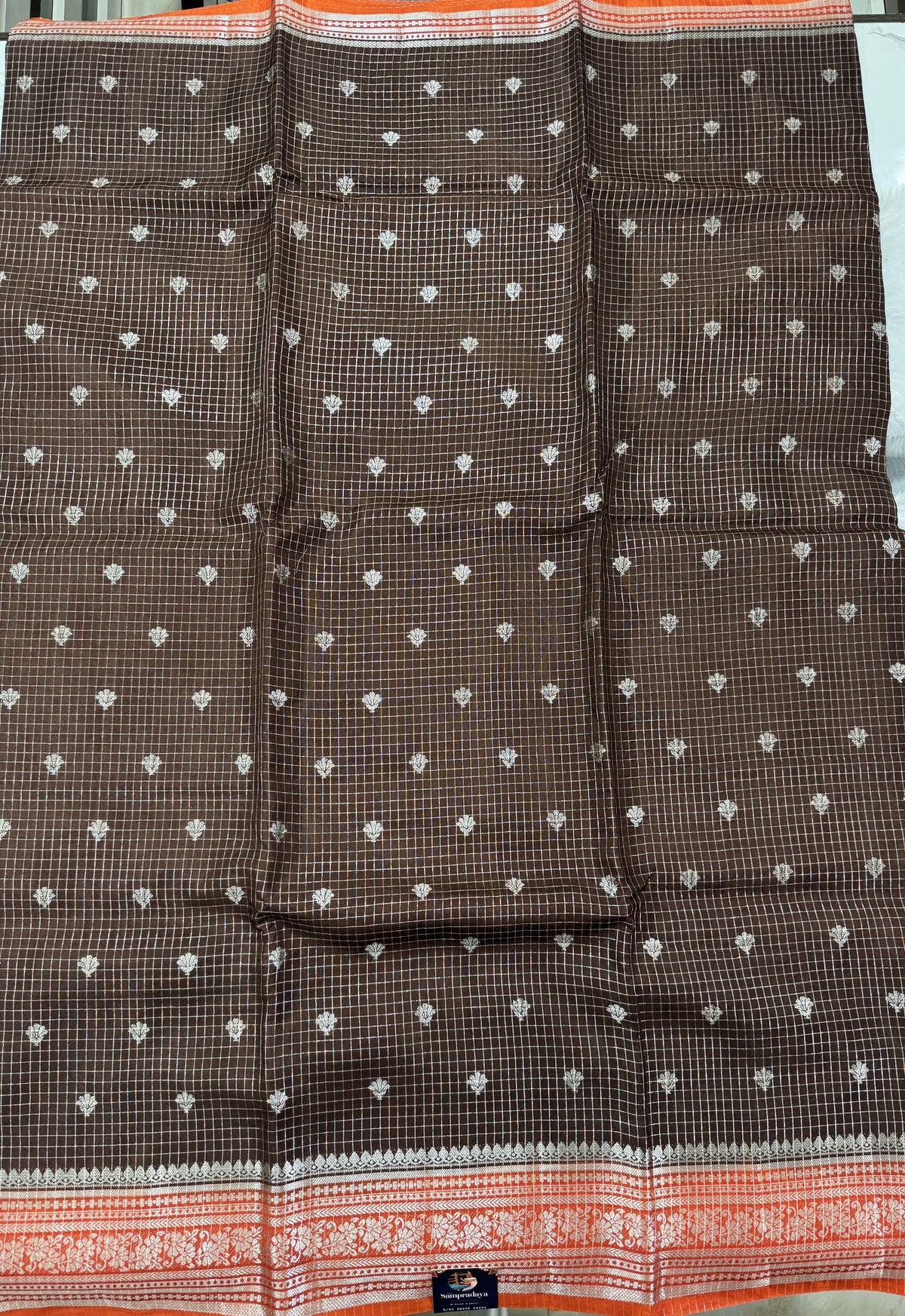 Banarasi Fancy Saree Brown Colored Complemented with a Orange Zari Border.