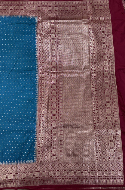 Banarasi Fancy Saree Teal Blue Colored Complemented with a Magenta Zari Border.